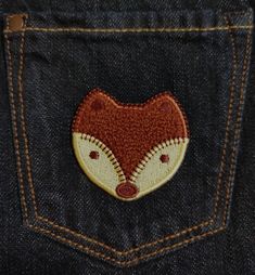 a close up of a pocket with a fox embroidered on the back of it's jeans