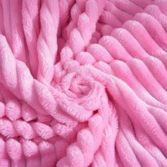 a pink blanket that is rolled up in the shape of a rose