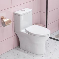 a white toilet sitting next to a pink tiled wall with a roll of toilet paper on it