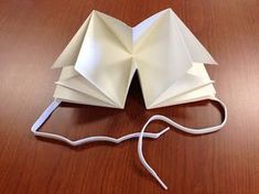 an origami book sitting on top of a wooden table next to a mouse