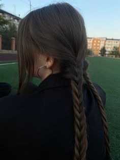 a woman with long hair is sitting on the grass