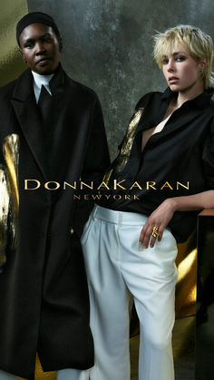 two people standing next to each other in front of a gold and black wall with the words donna karan new york on it