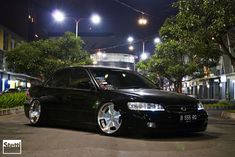 a black car parked on the street at night