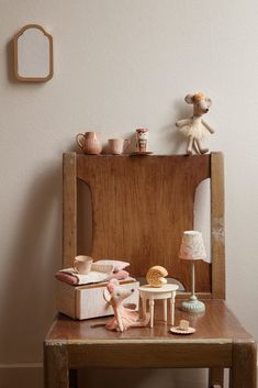 a small wooden table with various items on it and a teddy bear next to it