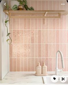 a kitchen with pink tiles on the wall and white counter tops, along with a wooden shelf