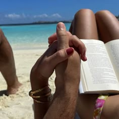 a person sitting on the beach reading a book