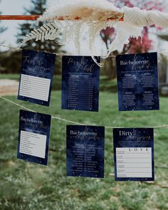 wedding seating cards hanging from a string in the grass