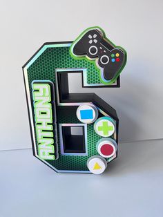 the letter e is made out of paper and has a video game controller on it