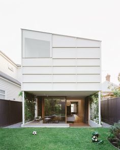 a house that has grass in front of it and some plants on the ground outside