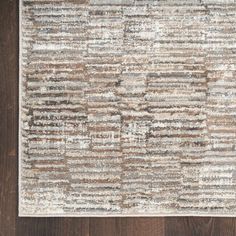 a brown and white rug on top of a wooden floor