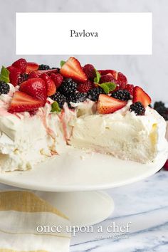 there is a cake with berries on it and the words pavlova above it