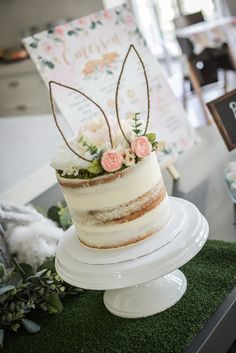 there is a cake with flowers on the top and an animal sign in the background