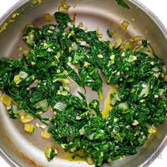 spinach and onions cooking in a pan on the stove