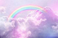 a rainbow in the sky with clouds