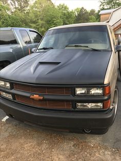 a truck parked in a parking lot next to other cars