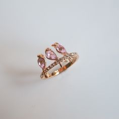 a gold ring with pink stones and diamonds