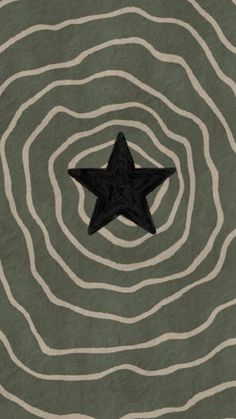 a black star sitting on top of a green and white floor next to wavy lines