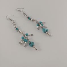 Turquoise Howlite Nuggets with silver beads make up this pair of dangling earrings that are fashionable for any outfit with a little bit of bohemian.  Pretty at best dangling from earlobe to approximately just below the jaw line.  Howlite stones are approximately 10mm in size.  Lightweight earrings that won't drag your lobes down.  ○ Ear wire.  ○ Hang from the ear lobes.  ○ Lightweight. ○ Fancy ○ Bohemian  Only 1 pair available! Silver Bead Earrings, Earrings Fancy, Earrings Dangling, Jaw Line, Silver Statement Earrings, Abstract Earrings, Fancy Earrings, Rainbow Earrings, Earrings Bohemian