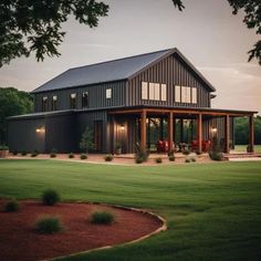 a large house sitting in the middle of a lush green field next to a forest