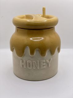 a honey jar with the word honey painted on it's front and bottom side