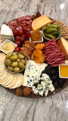 a platter filled with different types of cheeses, crackers and olives