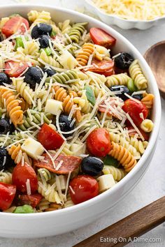 a pasta salad with tomatoes, olives, black olives and cheese