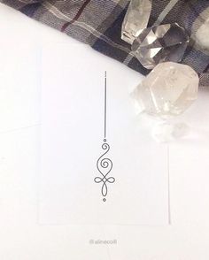 a piece of paper with a design on it next to some crystal beads and a plaid blanket