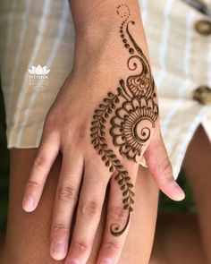 a woman's hand with a henna tattoo on her left arm and fingers