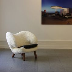 a white chair sitting in front of a painting