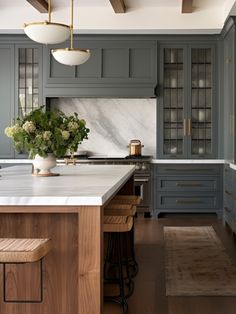 a kitchen with blue cabinets and marble counter tops