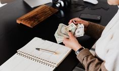 a woman sitting at a desk counting money