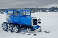 an old blue truck is parked in the snow with skis on it's tires