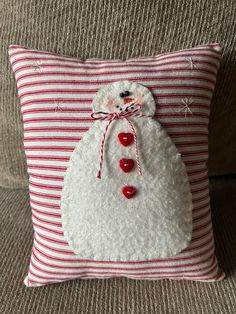 a white and red pillow with a snowman on it