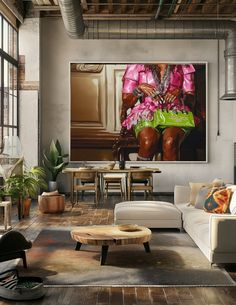 a living room filled with furniture and a painting hanging on the wall above it's coffee table