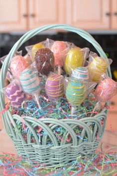 a basket filled with lots of colorful candies on top of a wooden table next to a counter