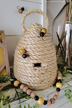 a basket with two bees sitting on top of it next to some other items and greenery