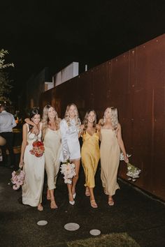 the bridesmaids are walking down the street together