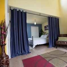 a bedroom with yellow walls and blue curtains