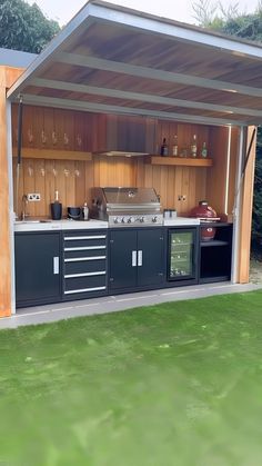 an outdoor kitchen is built into the side of a building with lots of storage space