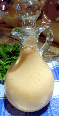 a glass bottle filled with liquid sitting on top of a blue and white checkered table cloth