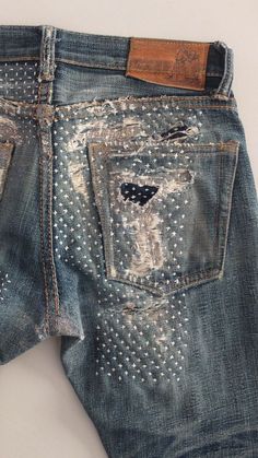 an old pair of jeans with holes and rivets