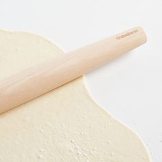 a wooden rolling pin laying on top of dough