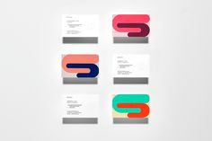 four business cards with different colors and shapes on white paper, arranged in the shape of letter s