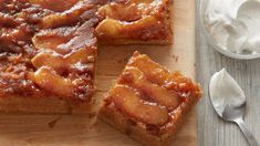 slices of apple upside down cake on a cutting board with whipped cream in the background