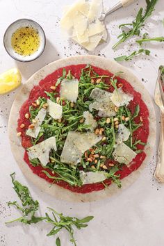 a pizza sitting on top of a table covered in cheese and vegtables