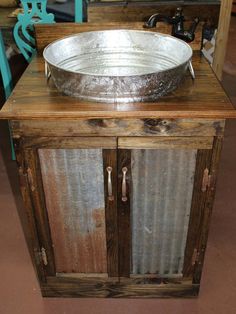 a metal bowl sitting on top of a wooden cabinet