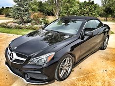 a black mercedes benz coupe parked in a driveway