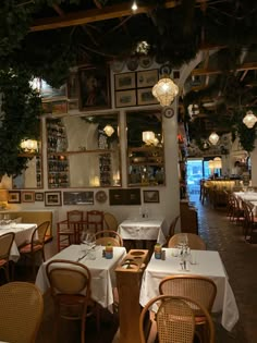 the interior of a restaurant with tables, chairs and pictures on the wall above them