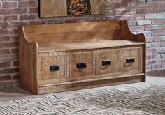 a wooden bench with four drawers in front of a brick wall and rug on the floor