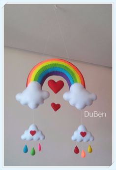 a rainbow mobile hanging from the ceiling with hearts and raindrops